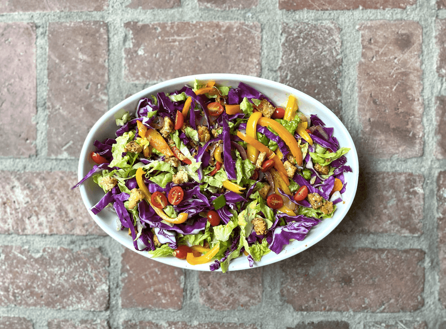 Ground tempeh in a bowl with vegetables. 