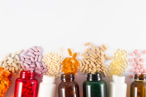 Bottles with different colored pills spilling out