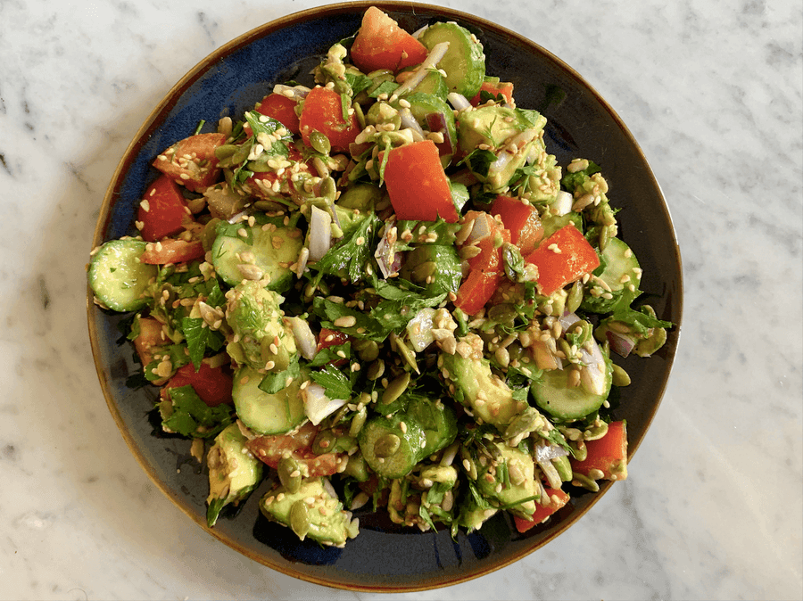 Avocado and seed salad on a blue plate