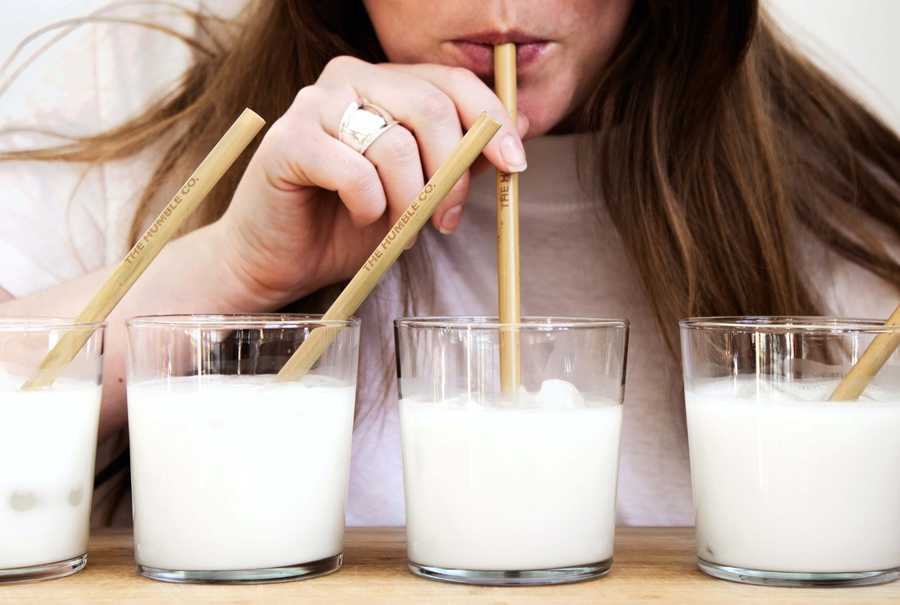Woman drinking glass of milk through a straw.