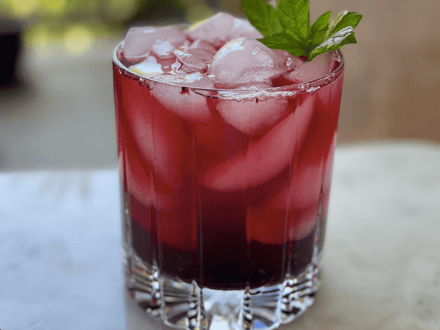 Crystal glass filled with ice and red liquid. 