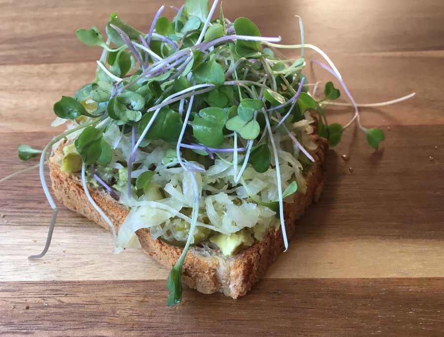 Homemade avocado toast with fermented cabbage and micro greens on top