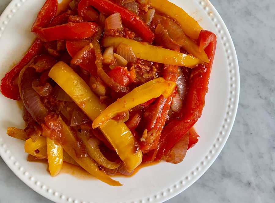 Stewed peppers and onions on a white plate
