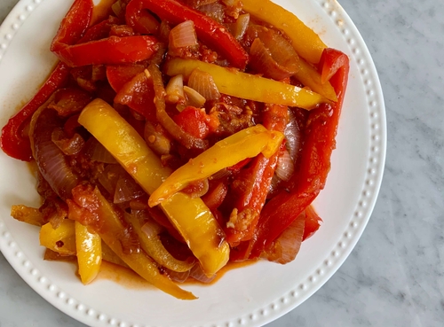 Stewed peppers and onions on a white plate